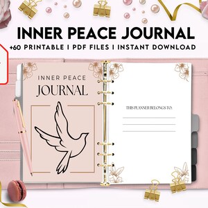 Pode incluir: Um di&aacute;rio rosa e dourado com o t&iacute;tulo "Inner Peace Journal" e o texto "Este planejador pertence a:". O di&aacute;rio tem um design de pombo e detalhes florais.