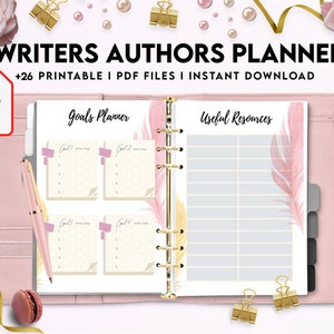May include: A pink and gold planner with the text "Writers Authors Planner" and "Goals Planner" and "Useful Resources". The planner has a ring binder and is decorated with feathers.