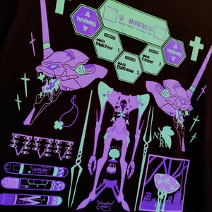 Puede incluir: Una camiseta negra con un estampado gr&aacute;fico en verde ne&oacute;n y morado de un robot, una criatura y otros s&iacute;mbolos. El texto "WARNING" y "DAMNATION PARTY" tambi&eacute;n est&aacute;n incluidos en el dise&ntilde;o.