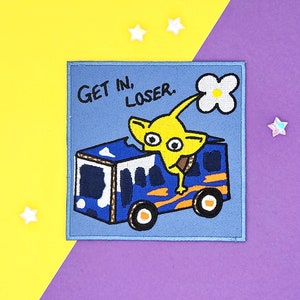 Pode incluir: Patch bordado com fundo azul apresentando um personagem de desenho animado amarelo segurando uma flor branca, saindo de um ônibus azul. O texto "GET IN, LOSER" está acima do personagem. O patch é quadrado com uma borda azul.