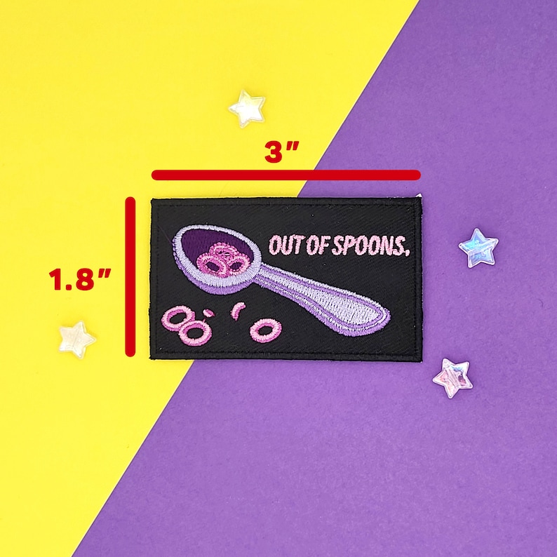 Puede incluir: Un parche de hierro bordado negro con una cuchara morada llena de anillos de cereal rosa y el texto "OUT OF SPOONS." El parche mide 7,6 cm de ancho por 4,6 cm de alto.
