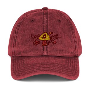 May include: A red vintage washed cotton baseball cap with an embroidered yellow and red mushroom with an eye design.