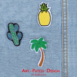 May include: Embroidered patches featuring a cactus, pineapple, and palm tree on a denim background. The cactus is green and blue, the pineapple is yellow, and the palm tree has a brown trunk and green fronds. The text "ART • PATCH • DESIGN" is visible.