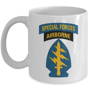 May include: White ceramic mug with a blue and gold Special Forces Airborne logo. The logo features a sword and lightning bolts.