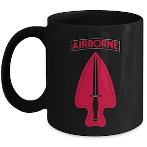 May include: Black ceramic coffee mug with a red and black airborne logo. The logo features a red arrowhead with a black dagger inside. The text "AIRBORNE" is printed in white above the logo.