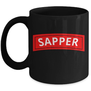 May include: Black ceramic coffee mug with a red rectangular label that says "SAPPER" in white text.