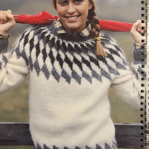 Puede incluir: Un suéter color crema con un patrón geométrico de diamantes en negro y gris. El suéter tiene mangas largas y cuello redondo. La imagen también muestra un paraguas rojo y el número 15 en la esquina superior izquierda.