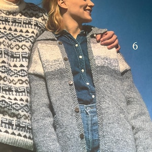 Puede incluir: Una mujer con una rebeca de punto gris con botones, sobre una camisa vaquera y vaqueros azules. La rebeca tiene un diseño de bloques de color gris claro y blanco. Una persona lleva un jersey con estampado blanco y gris.