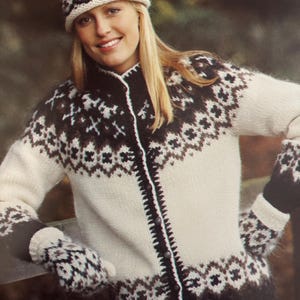 Puede incluir: Conjunto de punto color crema con gorro, cárdigan y mitones con un patrón geométrico marrón. El cárdigan tiene cierre de botones y ribete marrón oscuro. Los mitones tienen un patrón a juego. Un acogedor accesorio de invierno.