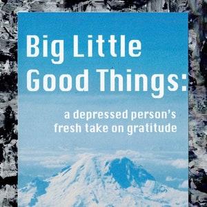 以下が含まれることがあります： 青い背景と背景に山脈がある本の表紙。タイトルは「Big Little Good Things: a depressed person's fresh take on gratitude」。著者の名前は「Devin S. Turk」。