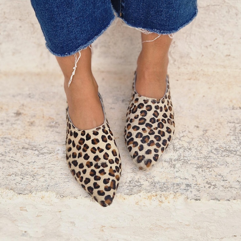 Pode incluir: Um par de sapatos baixos de bico fino com estampa de leopardo. Os sapatos baixos s&atilde;o feitos de um material macio, semelhante ao camur&ccedil;a, e t&ecirc;m um ajuste confort&aacute;vel.