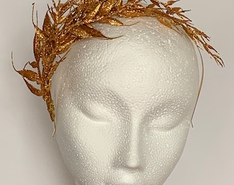 May include: A gold glitter leaf headband with a simple design. The headband is made of wire and is decorated with gold glitter leaves. The headband is perfect for adding a touch of sparkle to any outfit.