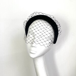 May include: A black velvet headband with a black tulle veil. The veil has a diamond pattern.