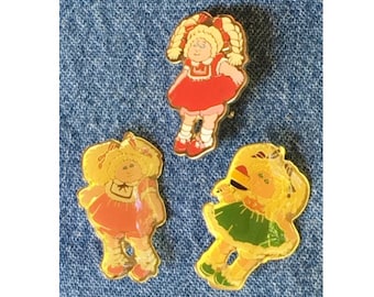 Cabbage Patch Doll Brooch Pin ~ Set of 3 ~ © 1983 OAA Inc. ~ Red, Orange, & Green Dress ~ by H. Eldon Ltd