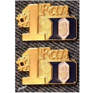 May include: Two gold-colored metal pins with the number one and the word "Fan" on them. The pins also feature a blue and white logo with a basketball inside.
