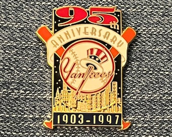 May include: A gold-colored pin commemorating the 95th anniversary of the New York Yankees. The pin features a baseball with the team's logo, a cityscape, and the years 1903-1997.