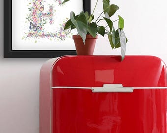 Può includere: Una stampa artistica incorniciata con la lettera "E" composta da fiori colorati e farfalle. L'opera d'arte è ambientata su uno sfondo bianco ed è esposta su un frigorifero retrò rosso. Una pianta in vaso è posta sopra il frigorifero.