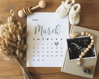 May include: A calendar page for March 2020 with a green heart marking the 6th. A black and white ultrasound image, a wooden baby rattle, and a beaded necklace are also in the image.