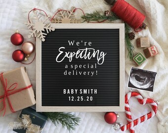 May include: A black letter board with white letters spelling "We're expecting a special delivery! Baby Smith 12.25.20". The board is surrounded by Christmas decorations, including snowflakes, ornaments, and candy canes.