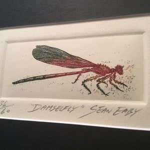 May include: A black and white print of a red dragonfly with green wings. The print is signed "Damselfly" Sean Eary and numbered 36/60.