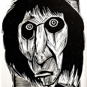 May include: Black and white linocut print of Alice Cooper. The artwork features a stylized portrait with exaggerated features, including large eyes and long hair. The print is signed "Sean Eaby" and titled "Alice Cooper".