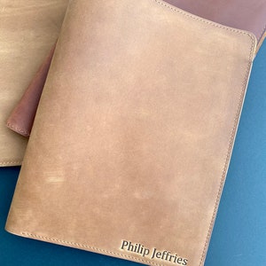 May include: A brown leather notebook with the name "Philip Jeffries" embossed on the front.