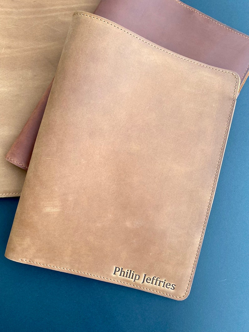 May include: A brown leather notebook with the name "Philip Jeffries" embossed on the front.