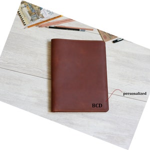 May include: A brown leather notebook cover with the initials "BCD" embossed on the front. The cover is personalized with the initials.