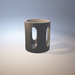 May include: A cylindrical object with a dark gray exterior and a lighter interior. The object has three elongated, oval-shaped cutouts. The object casts a shadow on the surface below.