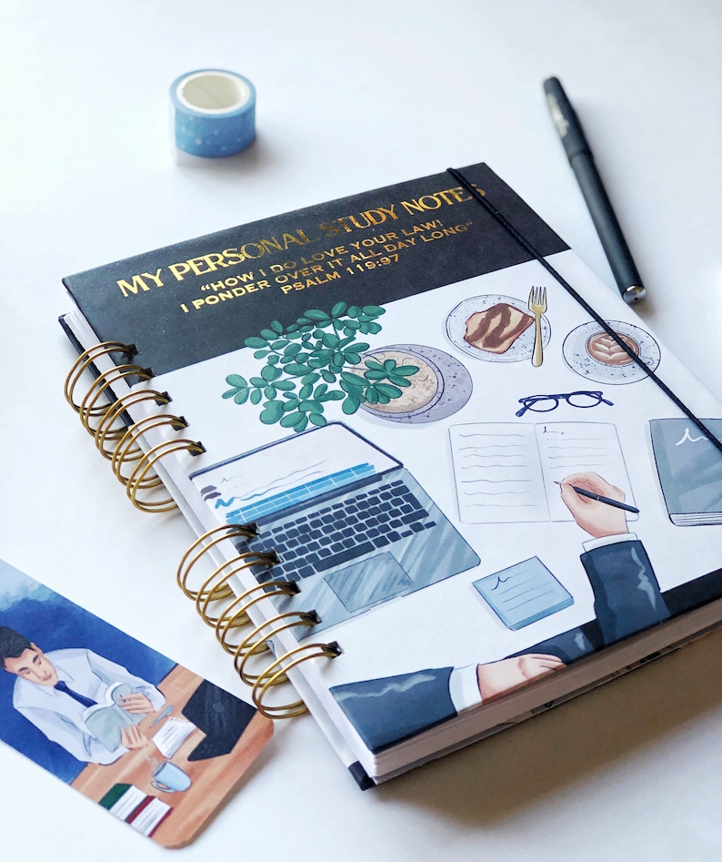 May include: A spiral-bound notebook with the text "MY PERSONAL STUDY NOTE" in gold lettering. The cover features illustrations of a laptop, food, and a person writing. A blue washi tape roll and a black pen are also visible.