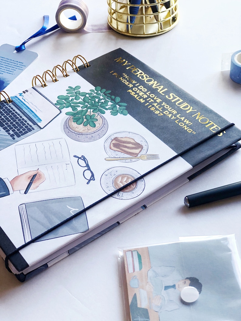 May include: A spiral-bound notebook with the text "MY PERSONAL STUDY NOTES" in gold lettering. The cover features illustrations of a laptop, potted plant, coffee, and cake. A black elastic band secures the notebook.