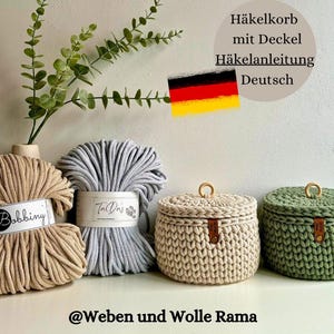 Könnte beinhalten: Zwei gehäkelte Aufbewahrungskörbe mit Deckel, einer beige und einer grün, mit Holzgriffen. Die Körbe sind aus dickem Baumwollseil gefertigt und stehen auf einem Tisch mit zwei Spulen Baumwollseil, einer beige und einer hellblau. Das Bild enthält den Text "@Weben und Wolle Rama".