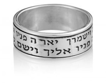 May include: A silver ring with Hebrew text inscribed around the band. The text reads "Shema Yisrael Adonai Eloheinu Adonai Echad" which translates to "Hear O Israel, the Lord our God, the Lord is One."