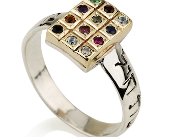 May include: A silver ring with a gold-colored rectangular top set with twelve colorful gemstones. The ring band has etched details. The gemstones are various colors, including red, blue, green, and clear.