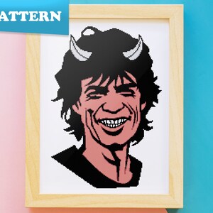 May include: A pixel art cross-stitch pattern of a man with black hair and a devilish grin, wearing a black shirt and horns. The pattern is designed for cross-stitch and is suitable for beginners.