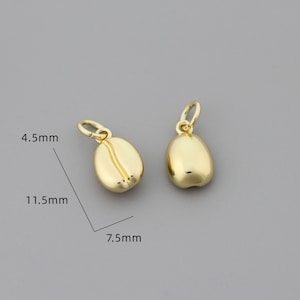 K&ouml;nnte beinhalten: Zwei goldfarbene Kaffebohnen-Anh&auml;nger, jeder misst 11,5 mm x 7,5 mm. Die Anh&auml;nger sind 4,5 mm dick.