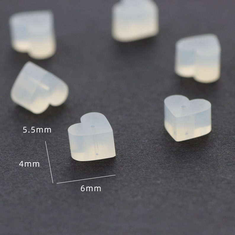 May include: Six clear heart-shaped silicone earring backs. The backs are 5.5 mm wide, 4 mm high, and 6 mm long.