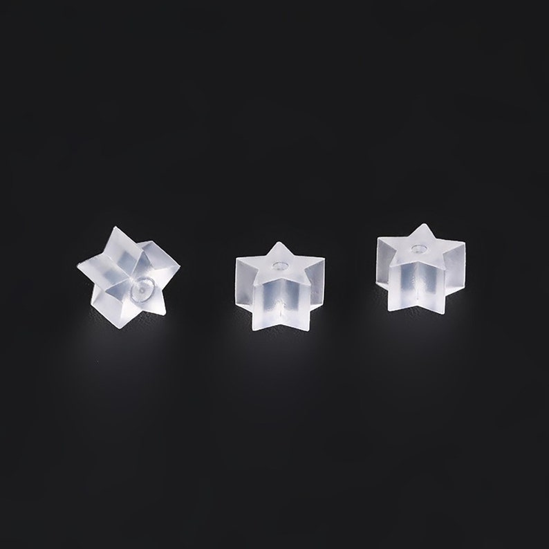 May include: Three clear plastic star-shaped earring backs.