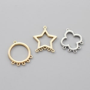 May include: Three gold-toned metal charms with open designs. The charms are a circle, a star, and a four-leaf clover. Each charm has five small loops around the edge.
