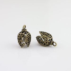 May include: Two antique gold filigree metal bell-shaped pendant caps with a decorative design.