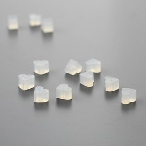 May include: A group of small, clear heart-shaped silicone earplugs.
