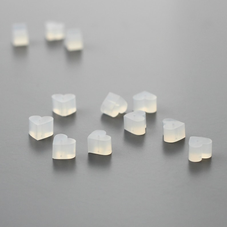 May include: A group of small, clear heart-shaped silicone earplugs.