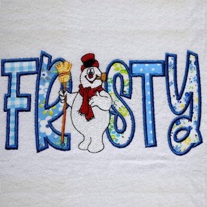 Peut inclure: Serviette blanche brodée avec le mot "Frosty" en lettres bleues à motifs. Un bonhomme de neige avec une écharpe rouge et un chapeau noir, tenant un balai, est au centre.