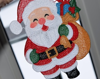May include: Embroidered Santa Claus figure with a smiling face, red suit, and white beard. He carries a sack of gifts and wears a black belt with a gold buckle. The figure has green gloves and black boots, perfect for Christmas decorations.