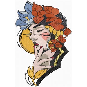 Può includere: Un ricamo colorato che rappresenta un viso di donna con gli occhi chiusi, circondato da fiori e foglie stilizzati in tonalità di blu, rosso, giallo e nero.