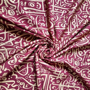 Tessuto bordeaux con stampe metalliche di calligrafie arabe: perfetto per eleganti caftani o accessori chic. Venduto da 50 cm