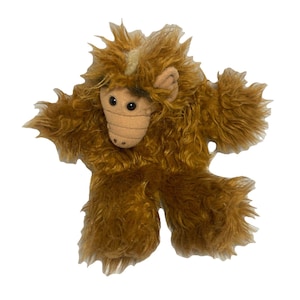 May include: A brown plush toy in the shape of a character with a tan face, large ears, and a furry body. The toy has a stitched nose and mouth, and large black eyes. The toy's arms and legs are outstretched.