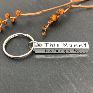 May include: Silver keychain with a rectangular tag that reads "This Mummy belongs to..."