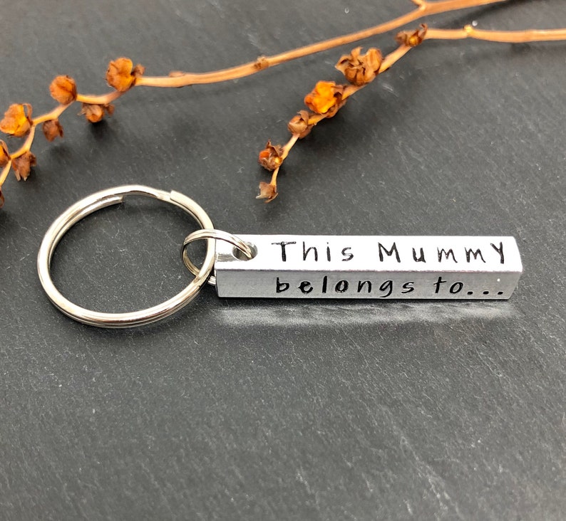May include: Silver keychain with a rectangular tag that reads "This Mummy belongs to..."