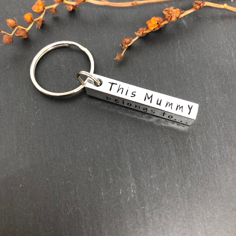 May include: Silver keychain with a rectangular tag that reads "This Mummy belongs to..."